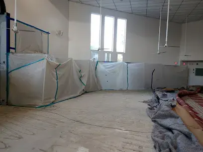 Plastic containment sheeting hung to seal off a drying area in an empty room
