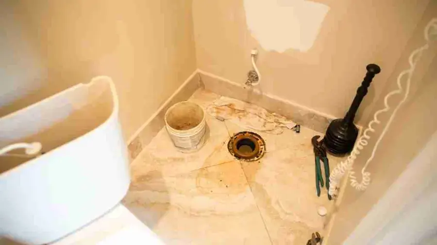 Bathroom with the toilet pulled and a soiled floor after a sewage backup