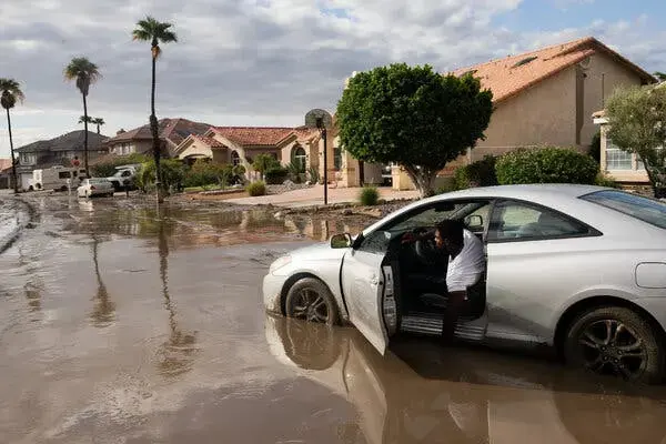 Storm runoff flooding a Southern California street of stucco homes